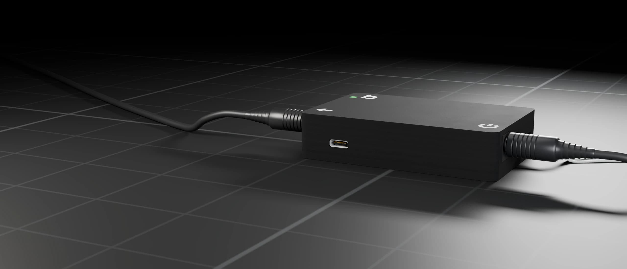 FanBridge v1 на темній підлозі студії, з DC-штекером на кожному кінці й портом USB-C спереду